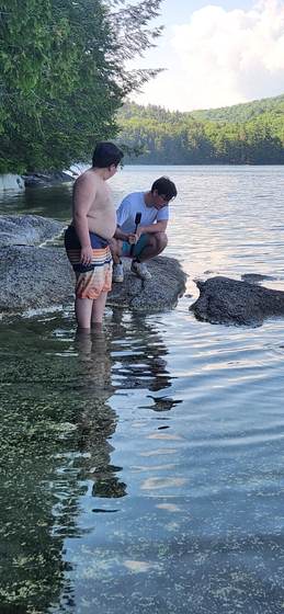 The boys watching tadpoles in the shallows on a summer afternoon