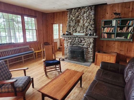 Stone fireplace, bookshelves and seating in a cabin