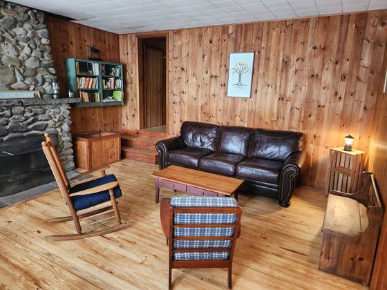 The living room and stone fireplace inside a cabin