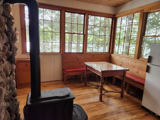 Wood stove and dining table in a cabin sunroom