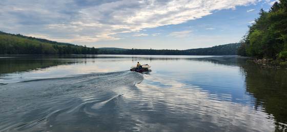 A boat heading out across Craig Pond at dusk
